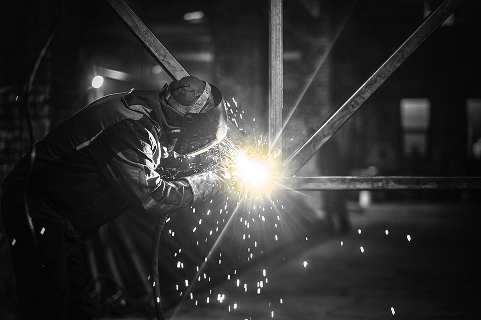 Man is working at the busy metal factory